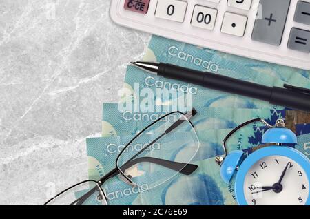 5 kanadische Dollar Rechnungen und Rechner mit Brille und Stift. Geschäftskredit oder Steuerzahlung Saisonkonzept. Finanzplanung und Zeit, Steuern zu zahlen Stockfoto