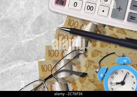 100 kanadische Dollar Rechnungen und Rechner mit Brille und Stift. Geschäftskredit oder Steuerzahlung Saisonkonzept. Finanzplanung und Zeit, Steuern zu zahlen Stockfoto