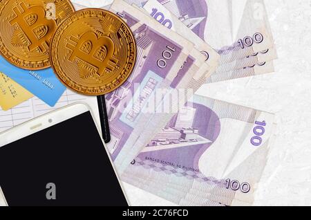 100 philippinische Piso-Scheine und goldene Bitcoins mit Smartphone und Kreditkarten. Investitionskonzept für Kryptowährungen. Krypto-Bergbau oder Handel mit transactio Stockfoto