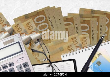 100 kanadische Dollar Rechnungen und Rechner mit Brille und Stift. Tax Payment Saison Konzept oder Investment-Lösungen. Finanzplanung oder Buchhalter p Stockfoto
