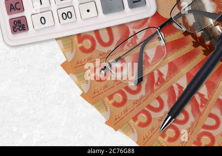 50 Kanadische Dollar Rechnungen Fächer und Rechner mit Brille und Stift. Geschäftskredit oder Steuerzahlung Saisonkonzept. Finanzplanung Stockfoto