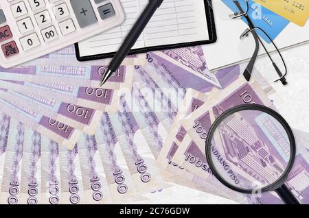 100 philippinische Piso Rechnungen und Rechner mit Brille und Stift. Tax Payment Saison Konzept oder Investment-Lösungen. Suche nach einem Job mit hohem Gehalt EA Stockfoto