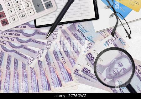100 philippinische Piso Rechnungen und Rechner mit Brille und Stift. Tax Payment Saison Konzept oder Investment-Lösungen. Suche nach einem Job mit hohem Gehalt EA Stockfoto