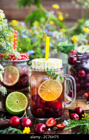 Gesunde hausgemachte kalte Limonade mit frischen Beeren und Früchten im Einmachglas Stockfoto