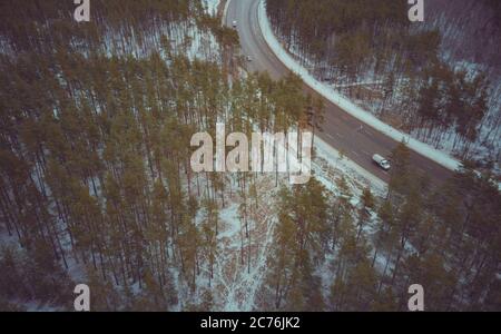 Verkehr an einem Wintertag. Autos auf der Straße im Winter mit schneebedeckten Bäumen Luftbild. Stockfoto