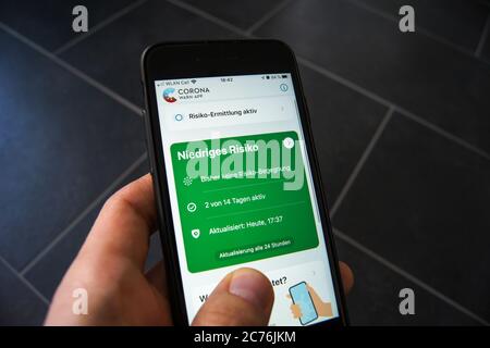 Corona Warn App der Bundesregierung auf einem Smartphone in der Hand eines Mannes. Entwickelt von SAP & Deutsche Telekom. Stockfoto
