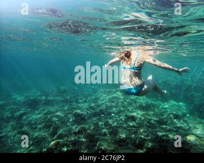 Unterwasseraufnahme einer Frau, die im Meer schwimmend ist, Bugibba, Malta Stockfoto