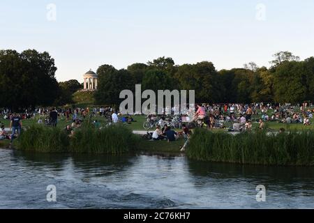 München, Deutschland. Juli 2020. Die Menschen genießen die Abendstimmung im Eisbach im Englischen Garten und lassen den Sommertag zu Ende gehen. Quelle: Felix Hörhager/dpa/Alamy Live News Stockfoto