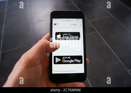 Corona Warn App Website der Bundesregierung auf einem Smartphone zeigt Download-Optionen von Apples App Store und dem Google App Store. Stockfoto