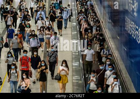 Passagiere mit Schutzmasken gehen durch die Hong Kong Station.die Regierung von Hongkong erlegt neue strenge soziale Distanzierungsmaßnahmen und das obligatorische Tragen von Gesichtsmasken für Menschen, die öffentliche Verkehrsmittel benutzen. Stockfoto