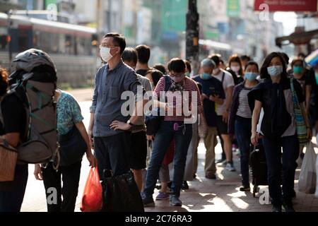 Hongkong, China. März 2020. Während der Coronavirus-Pandemie stehen Menschen an der Bushaltestelle in der Schlange, während sie Gesichtsmasken tragen.die Regierung hat die soziale Distanzierungsmaßnahme verschärft, da die Stadt 52 (einer der höchsten täglichen) neue Fälle von Coronavirus meldet. Kredit: May James/SOPA Images/ZUMA Wire/Alamy Live News Stockfoto