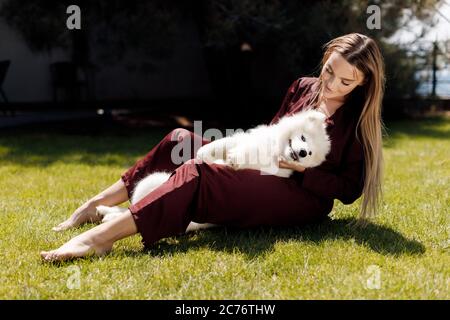 Junge lächelnde Frau mit Hund im Freien in der Nähe des Hauses Stockfoto