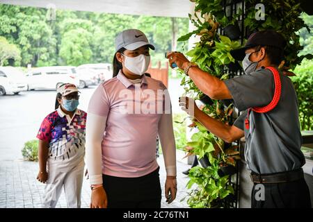 Nakronnayok, Thailand. Juli 2020. Sicherheitspersonal überprüft die Temperatur eines Golfers in Royal Hills, während die Golfplätze inmitten der Sperrebene 5 wieder geöffnet werden. Kredit: Amphol Thongmueangluang/SOPA Images/ZUMA Wire/Alamy Live Nachrichten Stockfoto