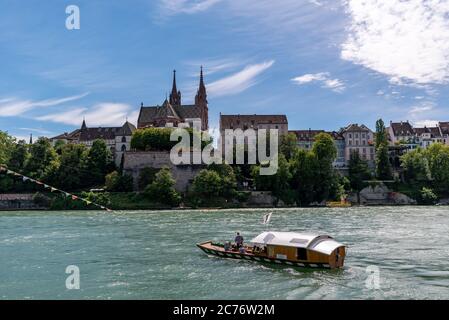 Basel, BL / Schweiz - 8. Juli 2020: Alte Holzfähre bringt Passagiere von Klein Basel nach Basel nur mit Rheinströmung Stockfoto