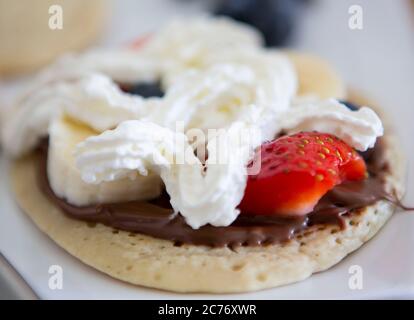 Hausgemachten veganen Pfannkuchen mit Erdbeeren, Sahne und Schokoladenaufstrich Stockfoto