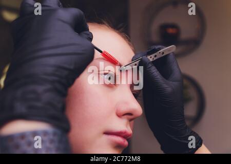 Make-Up. Kosmetikerin Hände Tun Augenbraue Tattoo Auf Frau Gesicht.Permanent Brow Make-Up In Schönheitssalon. Nahaufnahme Des Spezialisten, Der Augenbrauen Tätowiert Stockfoto