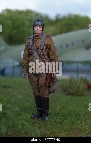 Eine junge Pilotin in Uniform der sowjetischen Armee Piloten während des Zweiten Weltkriegs Militär-Shirt mit Schulterriemen eines Major, Fallschirm, Flug helme Stockfoto