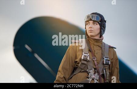 Eine junge Pilotin in Uniform der sowjetischen Armee Piloten während des Zweiten Weltkriegs Militär-Shirt mit Schulterriemen eines Major, Fallschirm, Flug helme Stockfoto