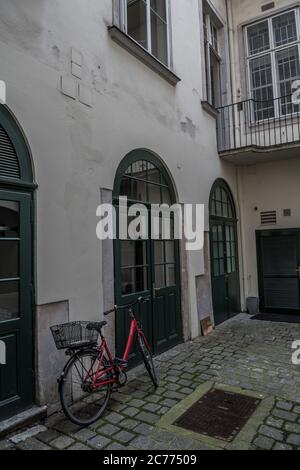 Hinterhof eines historischen Hauses mit EINEM gesperrten Vintage-Fahrrad in der Innenstadt von Wien in Österreich Stockfoto