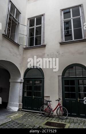 Hinterhof eines historischen Hauses mit EINEM gesperrten Vintage-Fahrrad in der Innenstadt von Wien in Österreich Stockfoto