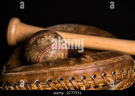 Alte Baseball, befleckt und wundert aus, und alten Stil catchers Fäustling von einem brandneuen Baseball-Schläger verbunden. Stockfoto