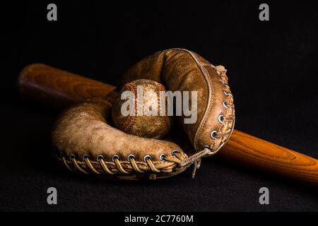 Antiker Fänger-Handschuh hält einen Baseball auf einem alten Holzschläger liegend. Stockfoto
