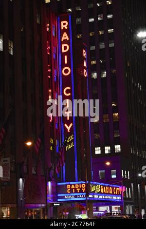 Das Art déco-Zelt mit Neonlicht leuchtet nachts in der Radio City Music Hall von der Sixth Avenue in New York City. Stockfoto