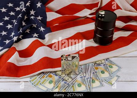 Öl des schwarzen Barrels Öl von hundert US-Dollar Scheinen auf einer Flagge in den USA Stockfoto