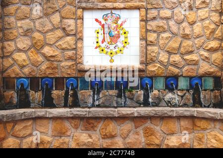 Polop de Marina, Costa Blanca, Spanien - 3. Oktober 2019: Brunnen mit einem Flaggenwappen von Alicante auf Fliesen im öffentlichen Park des Dorfes Stockfoto