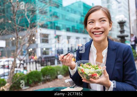 Mittagessen Salat nehmen Schüssel gesund essen asiatische Geschäftsfrau bereit, in City Park leben Lebensstil zu essen. Glücklich lächelnd multirassische chinesische junge