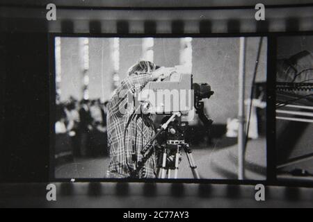 Feine 70s Vintage Kontakt Print schwarz-weiß Fotografie eines Kameramannes Rollen eine Filmkamera bei einer formalen Veranstaltung. Stockfoto