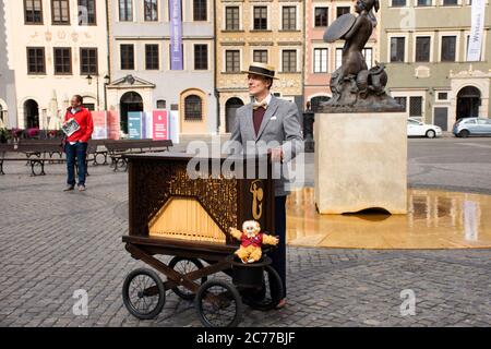 Polnische Menschen tragen Retro-Kleidung spielen antike Instrument Musik Box mobile für Show-Reisende auf dem Altstädter Marktplatz oder Rynek Starego Miasta W Stockfoto