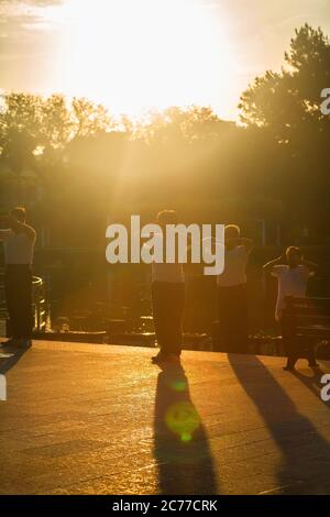 Eine Gruppe von 4 älteren Menschen praktiziert Tai Chi im Park während des Sonnenuntergangs. Taipeh, Taiwan Stockfoto