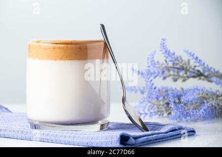 Dalgona Kaffee. Ein Glas trendiges Milchgetränk auf einer blauen Serviette. Stockfoto
