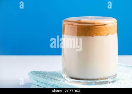 Dalgona Kaffee auf blauem Hintergrund. Modisches Trendgetränk aus Milch und süßen Schlagschaumstoffen. Für Text platzieren. Stockfoto