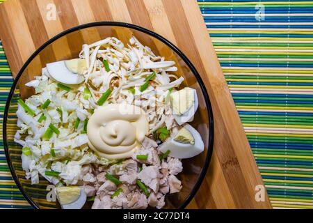 Diätetischer Salat für die richtige Ernährung mit Huhn und Eiern auf einer grünen Matte. Stockfoto