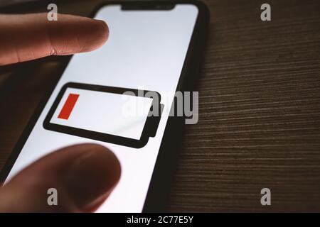 Smartphone mit niedrigem Akkustand. Symbol für niedrigen Akkustand aus nächster Nähe. Stockfoto