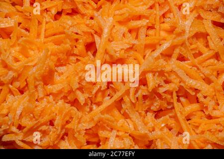 Geriebene Karotten in der Nähe. Hintergrund von zerkleinerten orangen Gemüse. Stockfoto