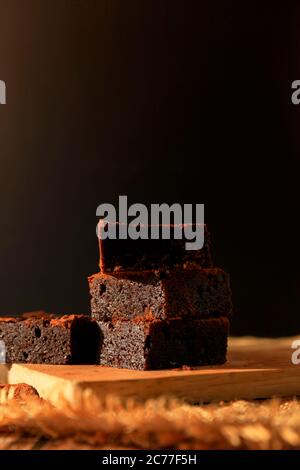 Stapel von Schokolade Brownies fudge auf Holzschlachter. Stack Brownies fudge mit Coco Pulver auf der Oberseite mit Kopierraum. Stockfoto