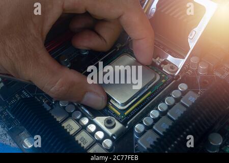 Nahaufnahme des Technikers, der die CPU auf den Sockel der Hauptplatine des Computers setzt Stockfoto