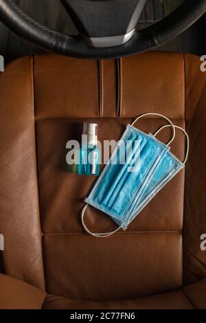 Draufsicht Medizinische Maske Alkohol Hand Desinfektionsmittel Gel auf dem Autositz . Stockfoto