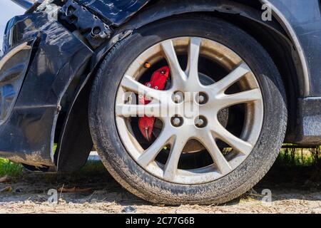 Nahaufnahme Reifen nach vorne schwarzen Auto beschädigt und durch Unfall auf der Straße gebrochen Stockfoto