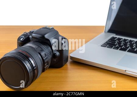 Digitalkamera und Laptop auf Holztisch isolieren auf weißem Hintergrund Stockfoto