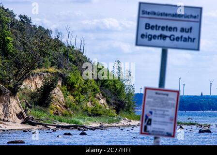 Timmendorf, Deutschland. Juli 2020. Warnschilder sind am Strand vor den Klippen auf der Ostseeinsel Poel in der Nähe des Timmendorfer Hafens angebracht. Nach Angaben des Schweriner Umweltministeriums sinkt die Steilküste zwischen den Städten Timmendorf und hinter Wangern in 100 Jahren ohne Küstenschutz um rund 55 Meter. Der Sand wird jedoch woanders gespült, so dass die Insel Poel nicht flächenmäsiger wird. Quelle: Jens Büttner/dpa-Zentralbild/ZB/dpa/Alamy Live News Stockfoto