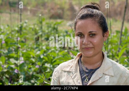 Junges Mädchen mit grünen Augen, das hart in einer Gemüsefarm unter einer starken Sonne in den Tropen arbeitet Stockfoto