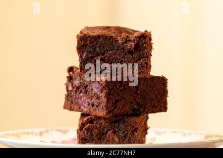Gebackene Brownies als Stapel von quadratischen Scheiben in dunkler Stimmung Stil Stockfoto
