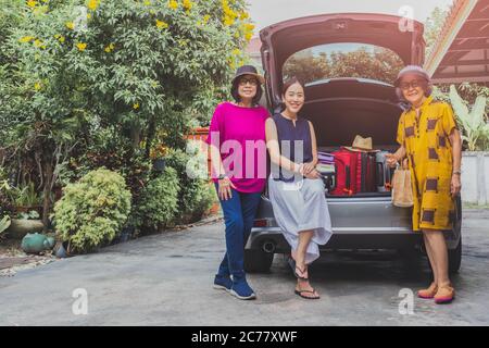 Zwei ältere Frauen und eine Erwachsene Frau mit Koffern auf Autotour. Stockfoto