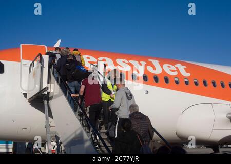 Passagiere, die Treppen hochgehen und ihre Tickets überprüfen lassen, steigen an einem klaren Wintertag an Bord eines Easyjet-Fluges am Flughafen Bristol ein Stockfoto