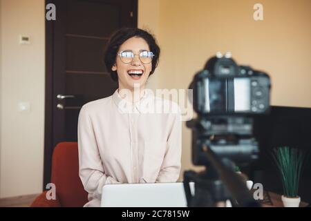 Kaukasische Frau mit Brille trägt ein Hemd mit einer Online-Lektion vor der Videokamera Stockfoto