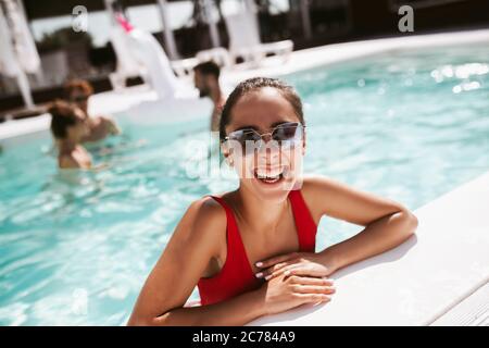Lächelnd junge hübsche Frau in einem roten Schwimmsuit genial Stockfoto